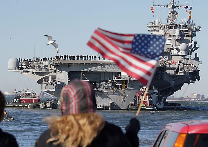 Kimberly Yurtsever of Norfolk waves an American flag as the nuclear powered aircraft carrier USS Enterprise deploys to support forces in Afghanistan at Naval Station Norfolk in Norfolk, Va., Thursday, Jan. 13, 2011. The USS Enterprise is deploying without its former commander as Navy brass investigates bawdy, sexually themed videos he showed to thousands of crew members. (AP Photo/Steve Helber)