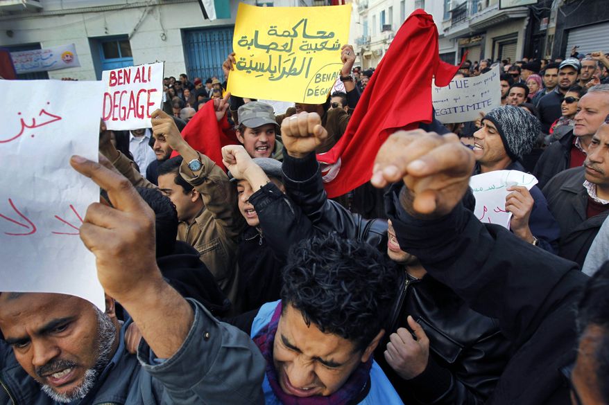 Demonstrators hold placards reading "Ben Ali get out" in Tunis, Friday, Jan. 14, 2011. Thousands of angry demonstrators marched through Tunisia's capital Friday, demanding the resignation of the country's autocratic leader a day after he appeared on TV to try to stop deadly riots that have swept the North African nation. (AP Photo/Christophe Ena)