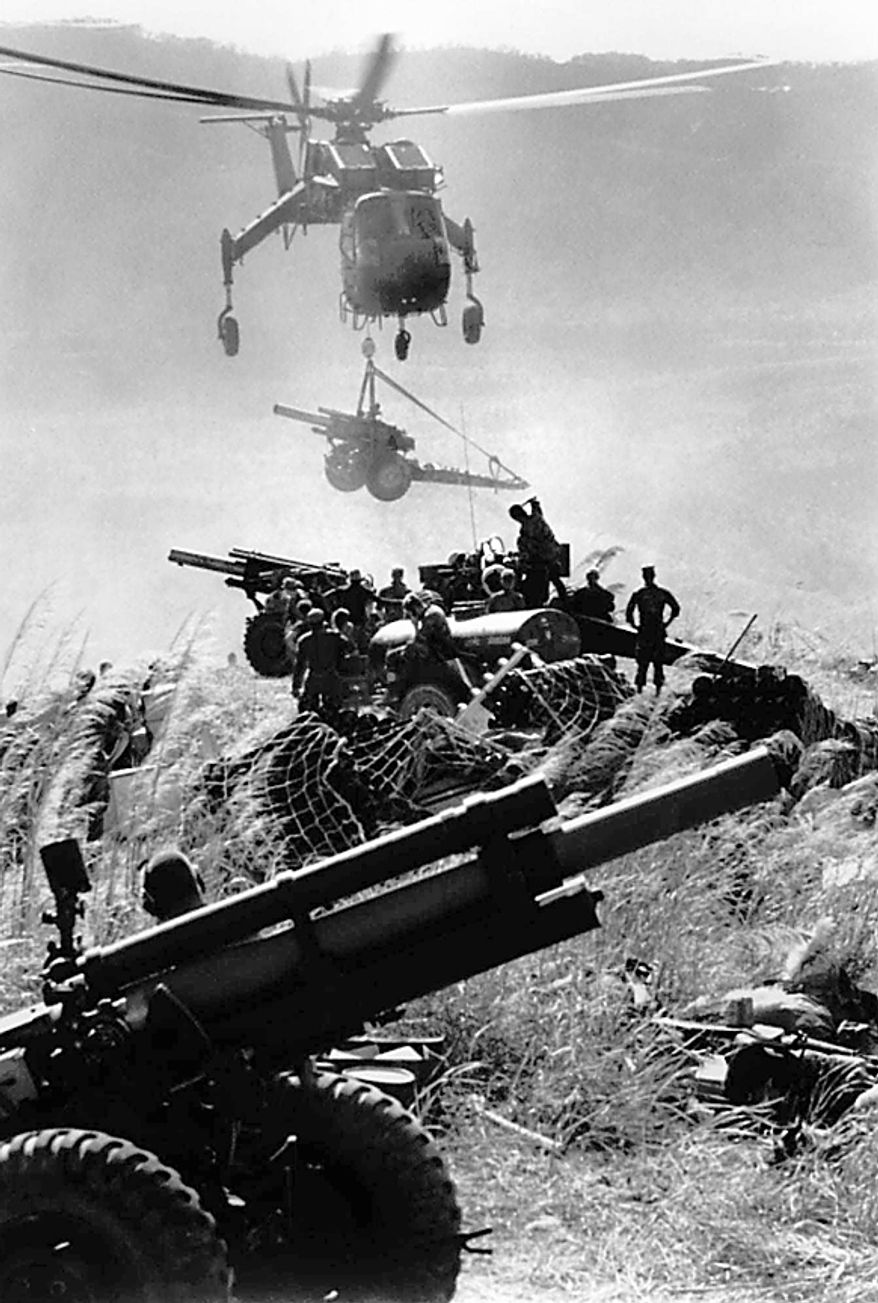 A helicopter lifts a 155mm howitzer cannon to the top of a hill during a U.S. Marines-South Vietnam thrust around Khe Sanh in January 1969. (AP Photo/Henri Huet)