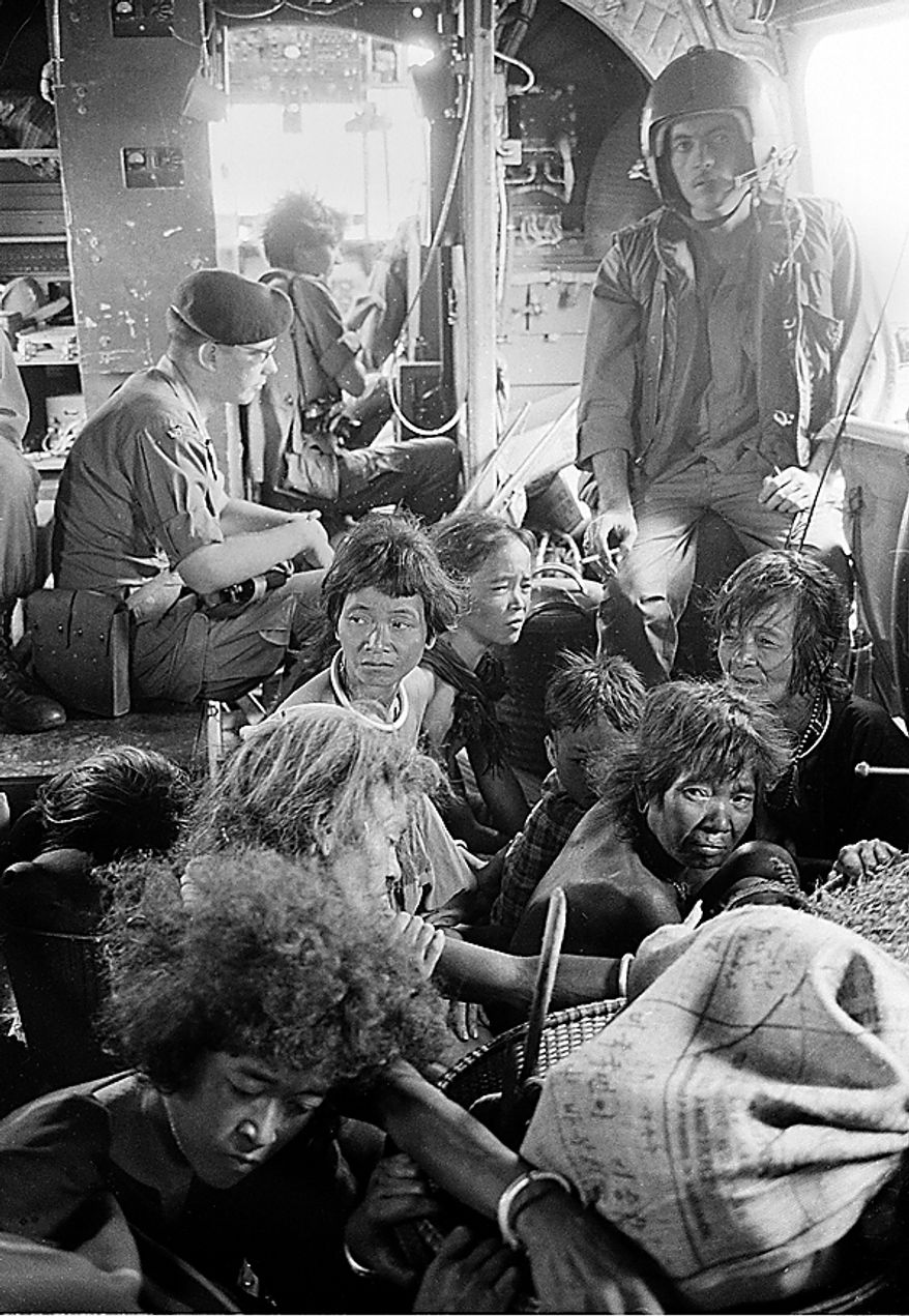 Members of the Montagnard tribe sit on the floor of an American helicopter taking them to their new home, a government refugee village, during the Vietnam War in Sept. 1968. (AP Photo/Henri Huet)