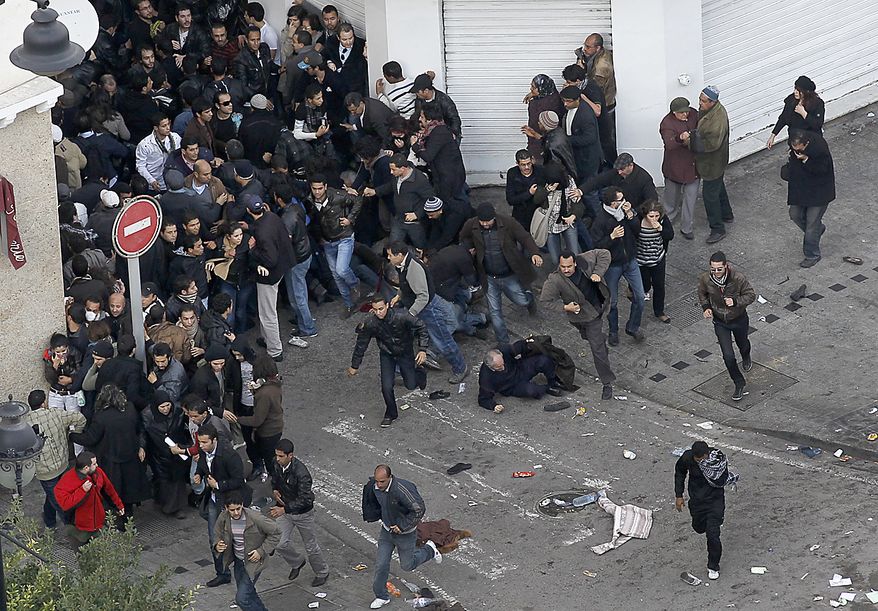 Protesters run to leave the demonstration as police throw teargas in Tunis, Friday, Jan. 14, 2011. Tunisia's president declared a state of emergency and announced that he would fire his government as violent protests escalated Friday, with gunfire echoing in the North African country's usually calm capital and police lobbing tear gas at protesters. (AP Photo/Christophe Ena)