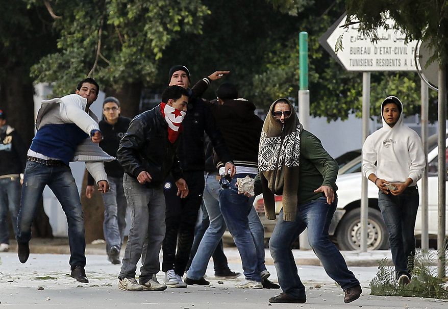 Demonstrators clash with police after a demonstration in Tunis, Friday, Jan. 14, 2011. Tunisia's president declared a state of emergency and announced that he would fire his government as violent protests escalated Friday, with gunfire echoing in the North African country's usually calm capital and police lobbing tear gas at protesters. (AP Photo/Christophe Ena)