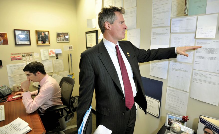 Sen. Scott Brown looks at thank-you notes affixed to a wall in his Boston office from constituents that his office had assisted. Austin Lord (left) is Mr. Brown's constituent-service official. "You need to make sure that you move the country forward," Mr. Brown said. (Associated Press)