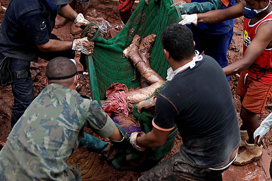 Rescue workers and residents recover the body of landslide victim Samara Coelho da Silva, 13, in Nova Friburgo, Brazil, Monday, Jan. 17, 2011. Brazil's army on Monday sent 700 soldiers to help throw a lifeline to desperate neighborhoods that have been cut off from food, water or help in recovering bodies since mudslides killed at least 642 people. (AP Photo/Felipe Dana)