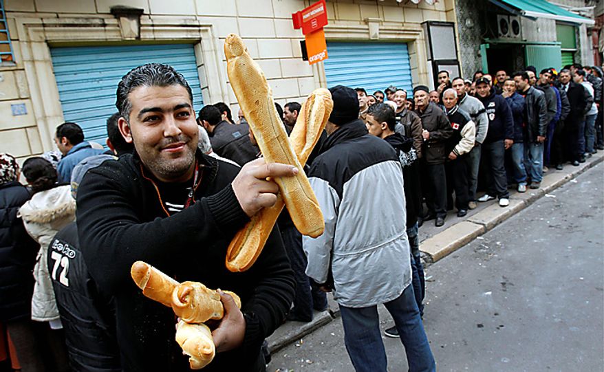 A man shows bread as he leaves a bakery in the center of Tunis, Monday, Jan. 17. 2011. A semblance of normal daily life returned in some areas of the capital on Monday, with once-shuttered shops, gas stations, pharmacies and supermarkets reopening and many people returning to their jobs. (AP Photo/Christophe Ena)