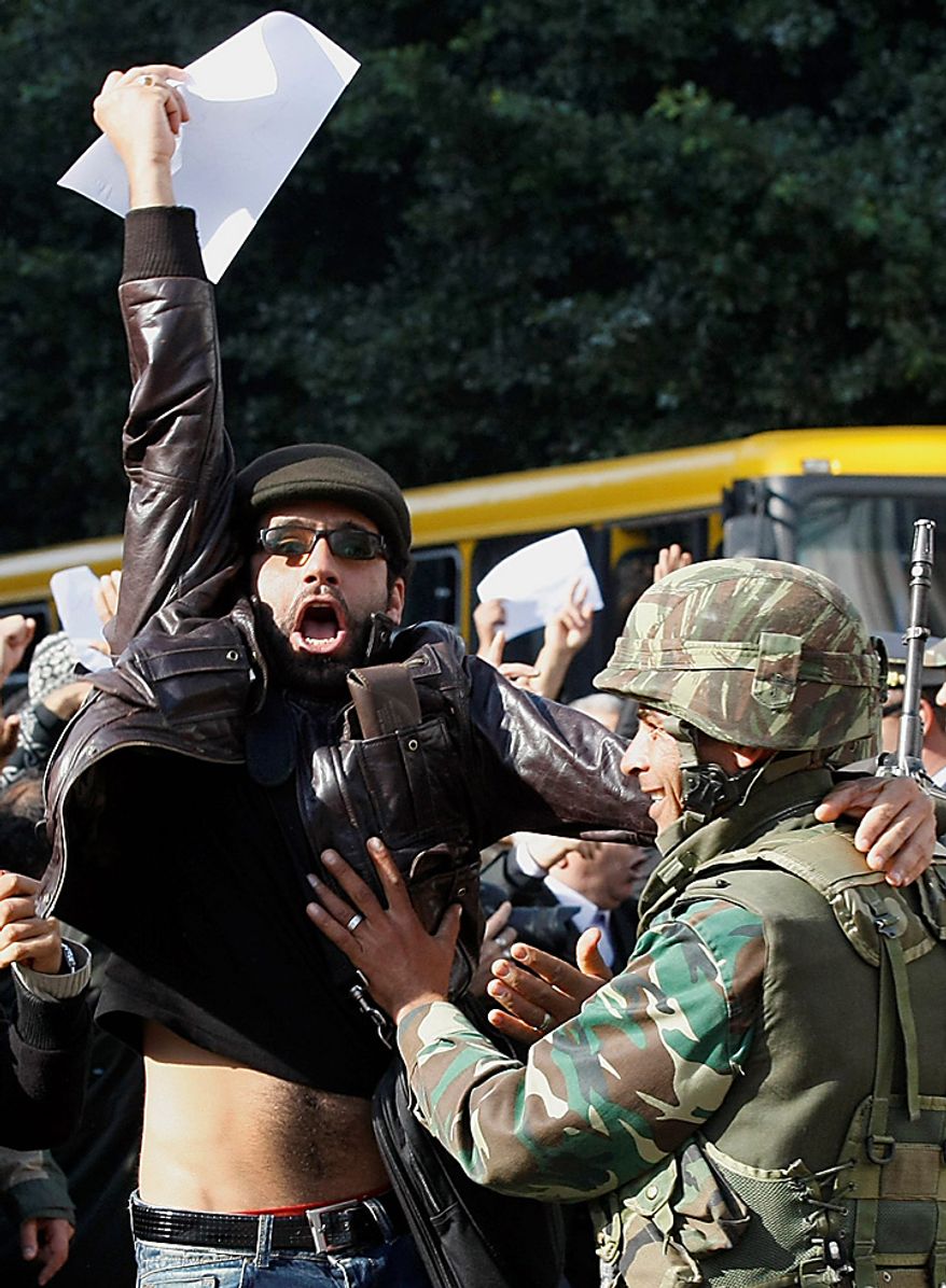 Protestors shout slogans against former Tunisian President Zine El Abidine Ben Ali in the center of Tunis, Monday, Jan. 17. 2011. Police were seen using tear gas to break up a demonstration on the main avenue in central Tunis on Monday, and helicopters were circling overhead. (AP Photo/Christophe Ena)