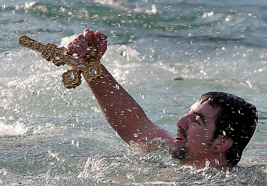 Miroslav Vukcevic retrieving the cross from the water of the river Ribnica,, in Podgorica, Montenegro, Wednesday, Jan. 19, 2011. Montenegrins celebrate Epiphany on January 19 , following old Julian calendar, with traditional retrieving of crosses from the rivers and lakes. (AP Photo/Risto Bozovic)