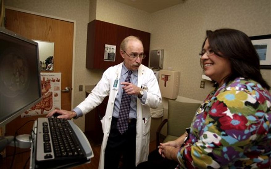 Dr. Paul J. Pockros, head, Division of Gastroenterology/ Hepatology and director, Liver Disease Center, talks with patient Loretta Roberts as they view her liver on a computer screen in his exam room at Scripps Green Hospital in San Diego, in this photo taken Jan. 13, 2011. (AP Photo/Lenny Ignelzi, File)