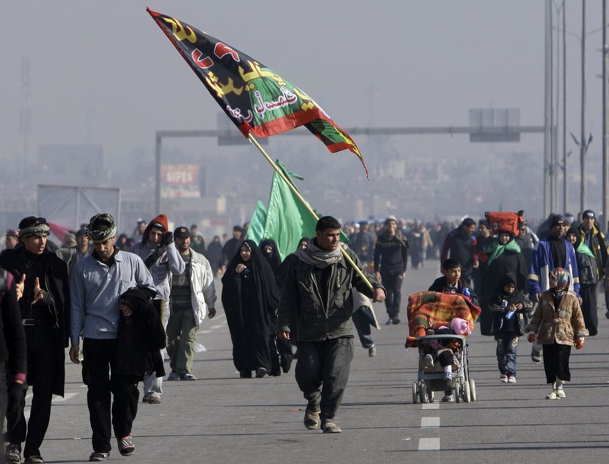 Shi'ite pilgrims march on their way to Karbala for Arbaeen, in Baghdad, Iraq, Thursday, Jan. 20, 2011. A pair of bombs blasted through security checkpoints ringing Karbala Thursday, Jan. 20, 2011, and killed at least 50 people, many of whom were Shi'ite pilgrims headed to observe yearly religious rituals. (AP Photo/Khalid Mohammed)