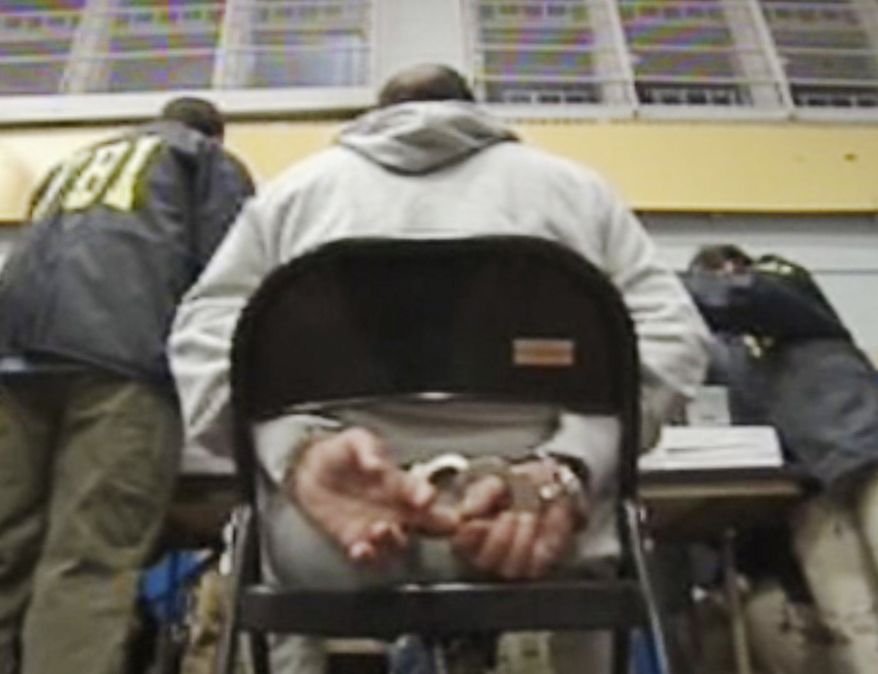 In this frame grab taken from Associated Press Television News video, a suspect sits handcuffed Thursday, Jan. 20, 2011, in the Brooklyn borough of New York. Federal agents dealt another major blow to New York's five Mafia crime families by arresting more than 100 suspected mobsters throughout the Northeast on charges including murder, extortion and narcotics trafficking. (AP Photo/APTN, Pool)