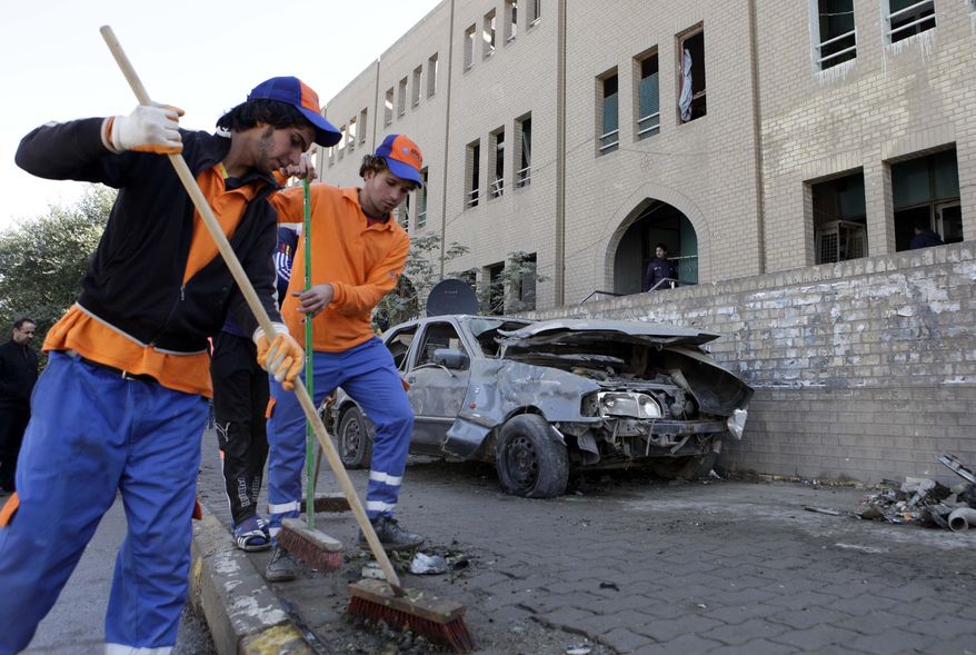 Workers sweep away debris after a bombing in Baghdad on Sunday, Jan. 23, 2011. A flurry of morning blasts killed and wounded several across the city, police said, in what one Iraqi official called an attempt to undermine security ahead of a much anticipated meeting of Arab heads of state in two months. (AP Photo/Karim Kadim)