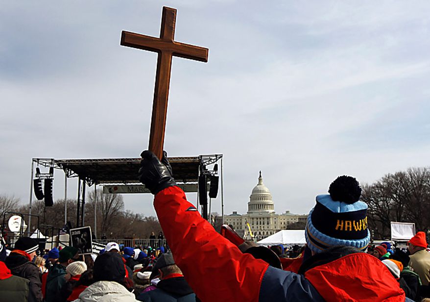 A man holds a cross during an anti-abortion rally on the National Mall in Washington on Monday, Jan. 24, 2011. The anniversary of the Supreme Court's Roe v. Wade decision was Saturday. (AP Photo/Alex Brandon)