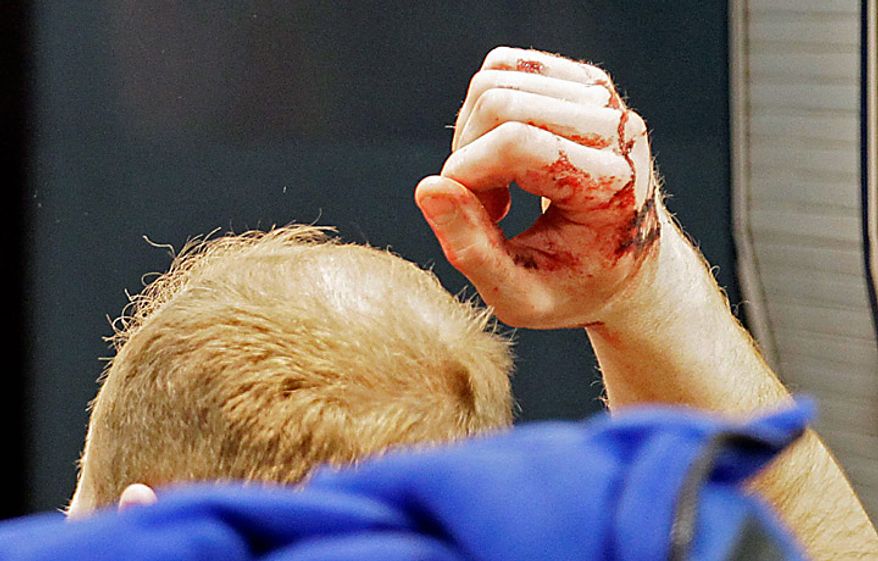 A man wounded in a blast is seen at Domodedovo Airport in Moscow, Monday, Jan. 24, 2011. An explosion ripped through the international arrivals hall at Moscow's busiest airport on Monday, killing dozens of people and wounding scores, officials said. Russian President Dmitry Medvedev called it a terror attack. (AP Photo/Ivan Sekretarev)