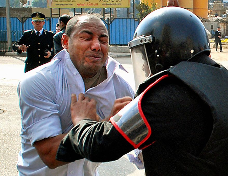 A protester scuffles with a riot policeman as he demonstrates in downtown Cairo, Egypt, Tuesday, Jan. 25, 2011. Hundreds of anti-government protesters marched in the Egyptian capital chanting against President Hosni Mubarak and calling for an end to poverty. (AP Photo/Mohammed Abu Zaid)