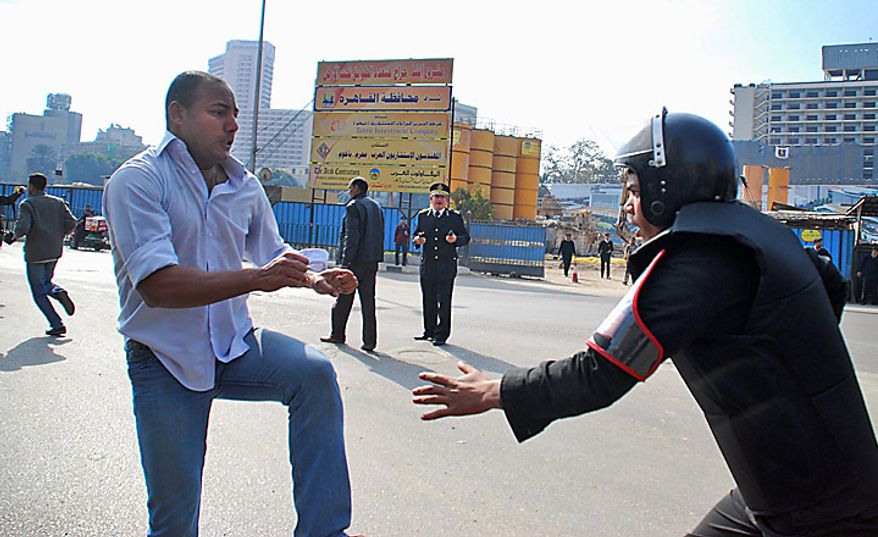 A protester confronts a riot policeman as he demonstrates in downtown Cairo, Egypt, Tuesday, Jan. 25, 2011. Hundreds of anti-government protesters marched in the Egyptian capital chanting against President Hosni Mubarak and calling for an end to poverty. (AP Photo/Mohammed Abu Zaid)