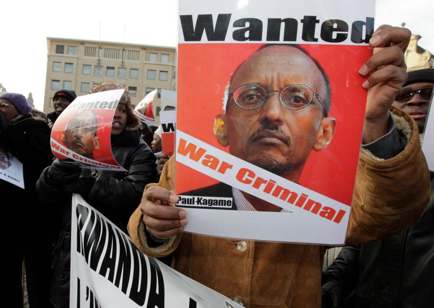 A man shows a poster of Rwandan President Paul Kagame to protest against his visit in Brussels last month. Four men who were once members of Mr. Kagame's inner circle have now fled the country. They say they fear for their lives even in exile as Mr. Kagame steps up efforts to silence their criticism. (Associated Press)
