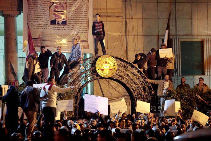 Egyptian anti-government activists chant slogans as they gather inside the Lawyers Syndicate in downtown Cairo on Wednesday. Beefed-up police forces on the streets quickly moved in and used tear gas and beatings to disperse demonstrations. (Associated Press)