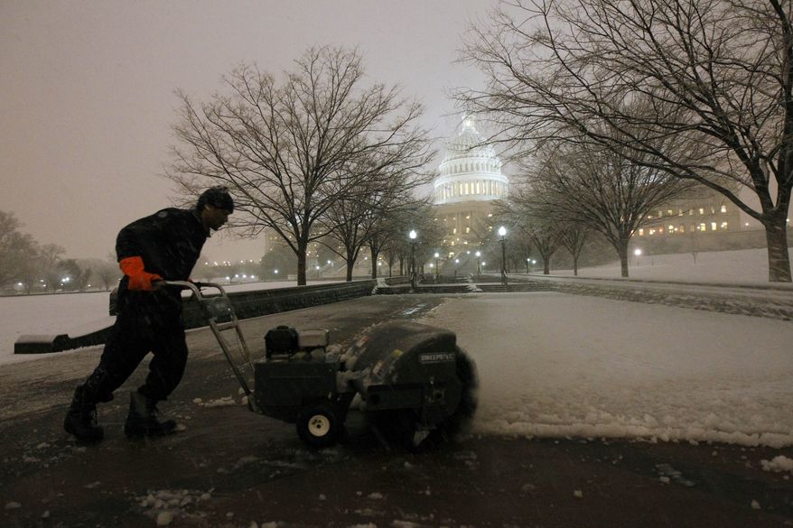 Deonte Lane works to remove the snow on the grounds of the U.S. Capitol as the snow continues to fall on Capitol Hill in Washington, Wednesday, Jan. 26, 2011.(AP Photo/Alex Brandon)