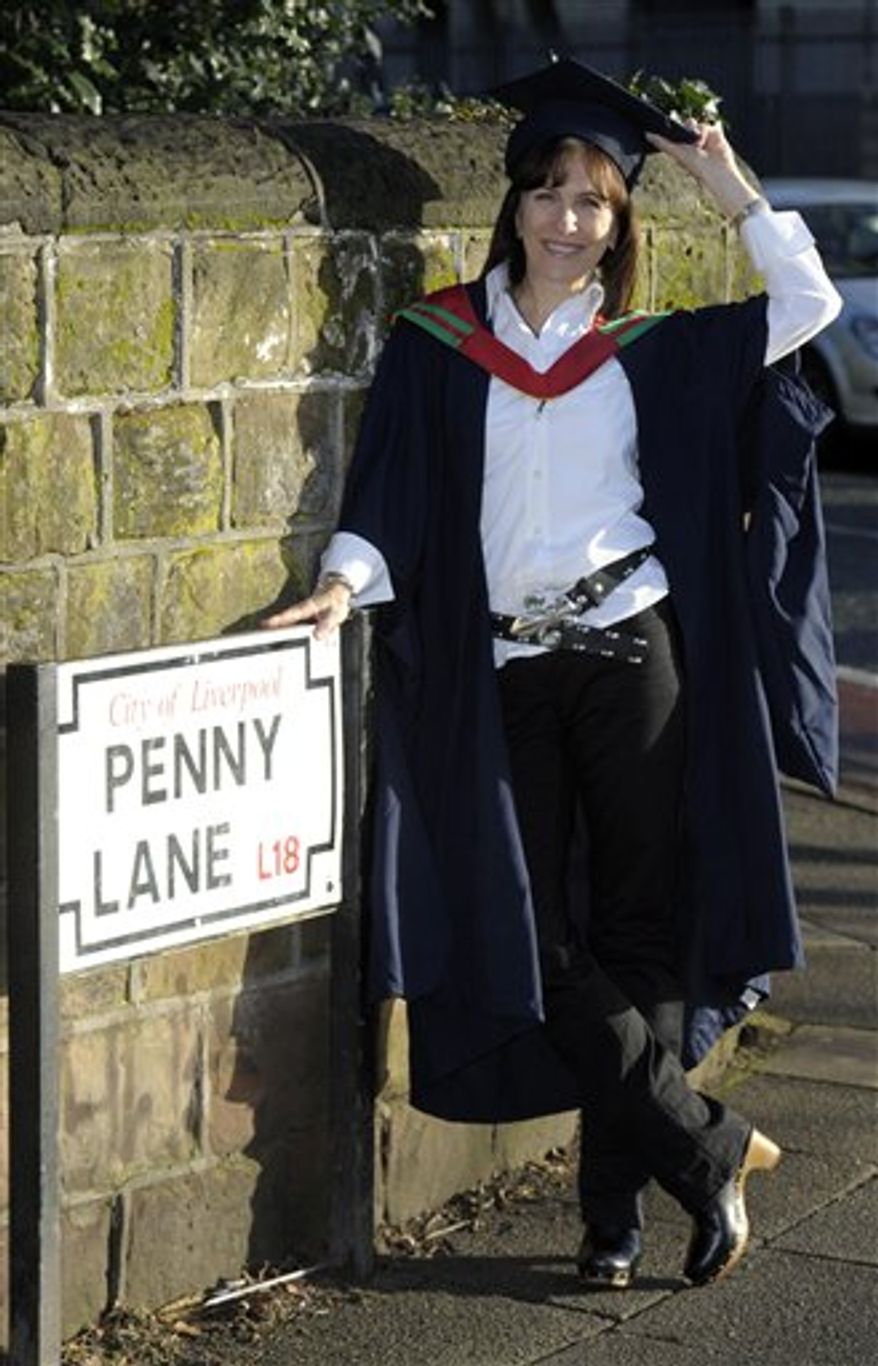 In this image made available by Liverpool Hope University, Wednesday Jan. 26, 2011, former Miss Canada finalist Mary-Lu Zahalan-Kennedy poses next to the Penny Lane street sign in Liverpool, England, after becoming the first person in the world to graduate with a Masters degree in The Beatles. Zahalan-Kennedy, 53, was one of the first students to sign up for the course on the Beatles when it launched at the university in March 2009. Twelve full-time students joined the Master of Arts course in The Beatles, Popular Music and Society that year and Mary-Lu is the first from her class to graduate.(AP Photo/Alan Edwards, Liverpool Hope University, ho) EDITORIAL USE ONLY: