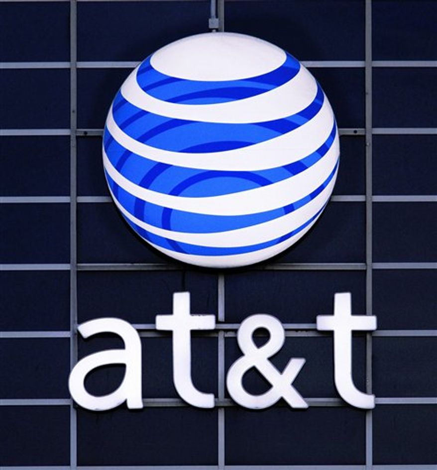 ** FILE ** The AT&T logo is displayed on the side of a corporate office in Springfield, Ill., in July 2010. (AP Photo/Seth Perlman, File)