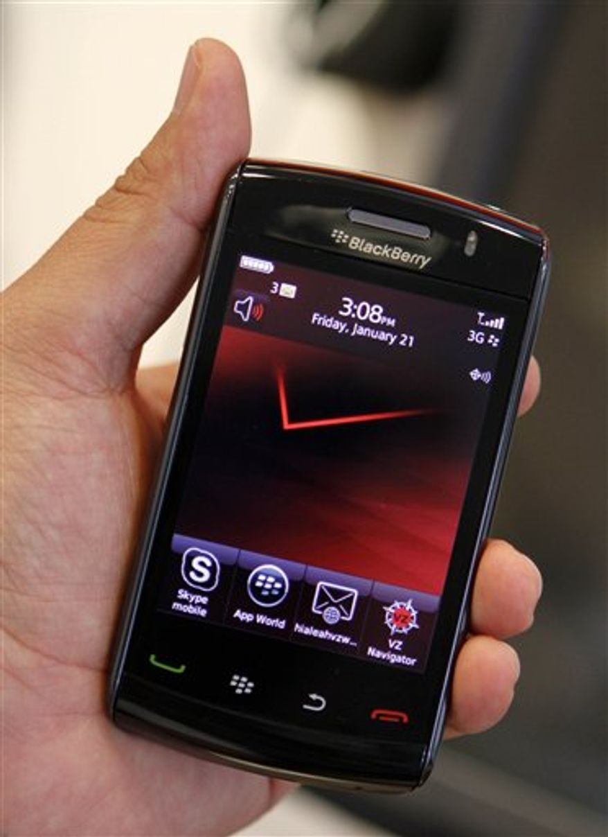 In this photo taken Friday, Jan. 21, 2011, a sales representative shows a Blackberry with the Verizon logo in Hialeah, Fla. Verizon said Tyesday, Jan. 25, it attracted more than half a million smart-phone subscribers in the last quarter, showing strength even before it starts selling the iPhone in February.(AP Photo/Alan Diaz)