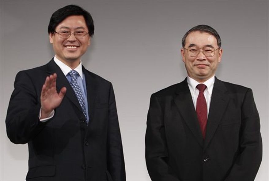 Lenovo Group Chief Executive Officer Yang Yuanqing, left, shakes hands with NEC President Nobuhiro Endo during a joint press conference in Tokyo Thursday, Jan. 27, 2011. NEC and China's Lenovo said Thursday they will join forces to create the largest personal computer business in Japan. (AP Photo/Shizuo Kambayashi)