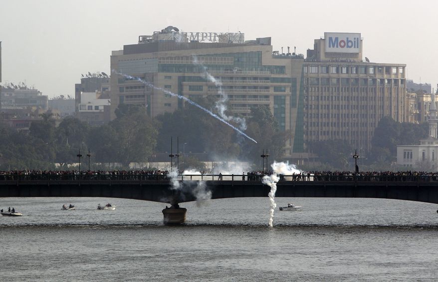 Tear gas launched by Egyptian police officers is seen over a bridge thronging with anti-government protesters during clashes in Cairo Friday, Jan. 28, 2011. Tens of thousands of anti-government protesters poured into the streets of Egypt Friday, stoning and confronting police who fired back with rubber bullets and tear gas in the most violent and chaotic scenes yet in the challenge to President Hosni Mubarak's 30-year rule. (AP Photo/Ben Curtis)
