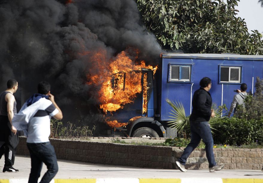 A police vehicle is engulfed in flames after it was set on fire during clashes with anti-government protesters in Cairo, Egypt, Friday, Jan. 28, 2011. Tens of thousands of anti-government protesters poured into the streets of Egypt Friday, stoning and confronting police who fired back with rubber bullets and tear gas in the most violent and chaotic scenes yet in the challenge to President Hosni Mubarak's 30-year rule. (AP Photo/Ben Curtis)