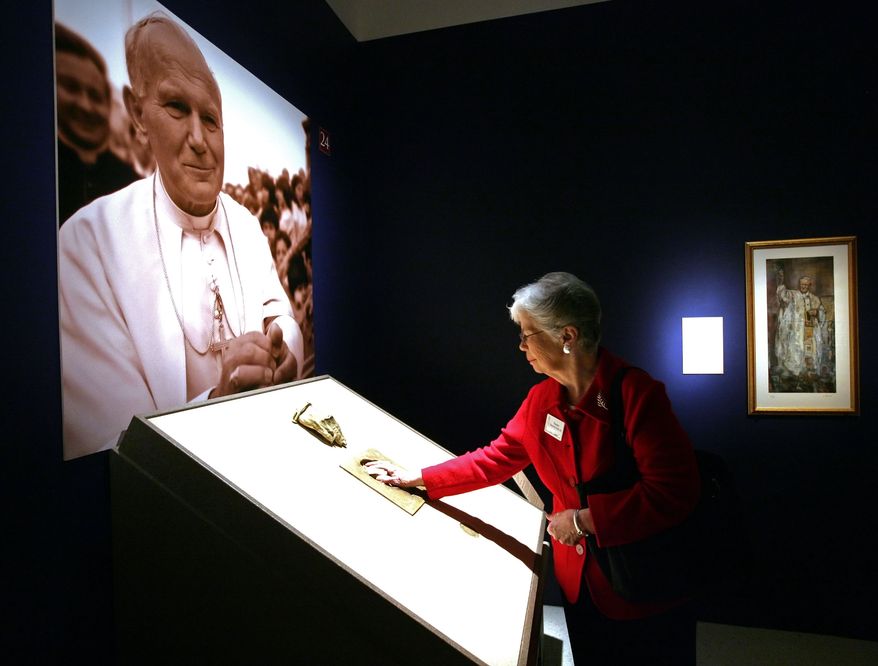 In this photo provided by the Museum of Art-Fort Lauderdale, Joan Tinsky places her hand into a cast of the hand of Pope John Paul II during a special media preview of "Vatican Splendors: A Journey through Faith and Art" on Thursday Jan. 27, 2011, at the Museum of Art/Fort Lauderdale in Fort Lauderdale, Fla. (AP Photo/Museum of Art-Fort Lauderdale, David Adame)