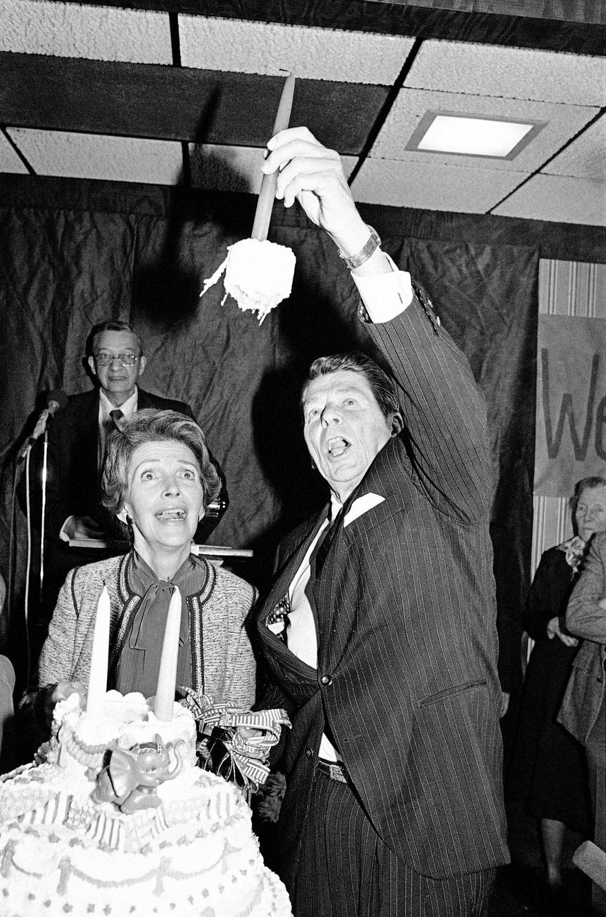 On the presidential campaign trail in Anderson, S.C., on Feb. 6, 1980, Ronald Reagan marks his 69th birthday, pulling up a chunk of the cake along with the candle, as wife Nancy looks on. Festivities will mark his birth centennial this week. (Associated Press)