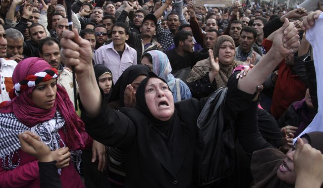 Women react during a demonstration in Cairo on Sunday, Jan. 30, 2011, as the Arab world&#x27;s most populous nation appeared to be swiftly moving closer to a point at which it either dissolves into widespread chaos or the military expands its presence and control of the streets. (AP Photo/Ahmed Ali)