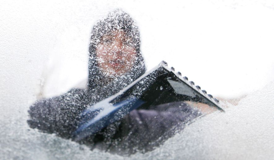 Lydia Vasquez scrapes ice from the windshield of her car in Denver on Monday, Jan. 31, 2011. A front moved through Colorado early Monday morning, bringing with it freezing rain, snow and cold. (AP Photo/Ed Andrieski)