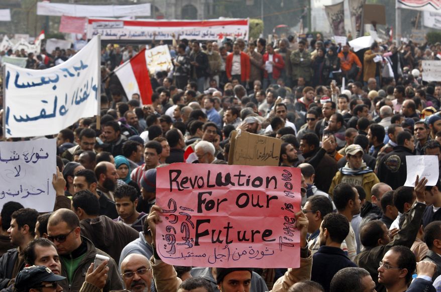 Demonstrators hold banners in Tahrir, or Liberation, Square in Cairo on Tuesday, Feb. 1, 2011, to demand that President Hosni Mubarak step down after nearly 30 years in power. (AP Photo/Khalil Hamra)