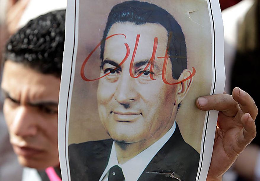 A demonstrator holds up a portrait of Egyptian President Hosni Mubarak in Tahrir, or Liberation, Square in Cairo on Tuesday, Feb. 1, 2011. More than a quarter-million people flooded into the heart of Cairo, filling the city's main square in by far the largest demonstration in a week of unceasing demands for President Hosni Mubarak to leave after nearly 30 years in power. (AP Photo/Ben Curtis)