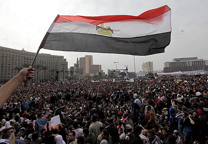 A demonstrator waves an Egyptian flag as the crowd gathers in Tahrir, or Liberation, Square in Cairo on Tuesday, Feb. 1, 2011. More than a quarter-million people flooded into the heart of Cairo, filling the city's main square in by far the largest demonstration in a week of unceasing demands for President Hosni Mubarak to leave after nearly 30 years in power. (AP Photo/Ben Curtis)
