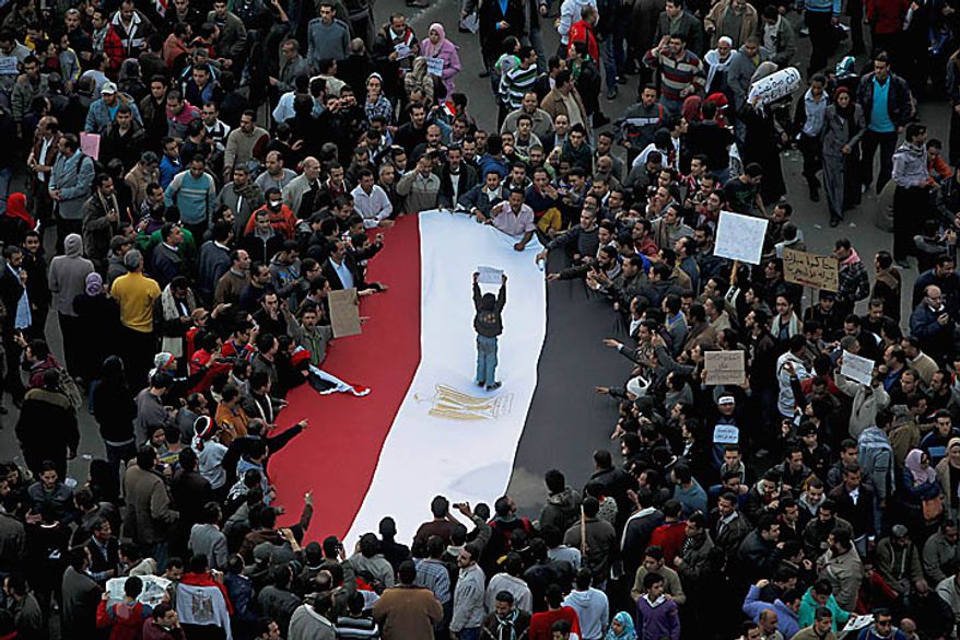 An Egyptian boy stands on an Egyptian flag as anti-government protesters crowd around in Tahrir, or Liberation, Square in Cairo on Tuesday, Feb. 1, 2011. More than a quarter-million people flooded into the heart of Cairo, filling the city's main square in by far the largest demonstration in a week of unceasing demands for President Hosni Mubarak to leave after nearly 30 years in power. (AP Photo/Tara Todras-Whitehill)