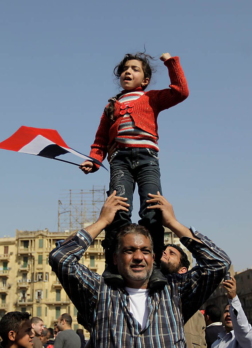 A girl standing on a man's shoulders reacts during a demonstration in Tahrir, or Liberation, Square in Cairo on Tuesday, Feb. 1, 2011. More than a quarter-million people flooded into the heart of Cairo Tuesday, filling the city's main square in by far the largest demonstration in a week of unceasing demands for President Hosni Mubarak to leave after nearly 30 years in power. (AP Photo/Ben Curtis)