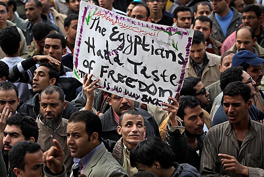 An anti-government protester holds a banner reading: "The Egyptians had a taste of freedom. There is no way back," during the continuing demonstration in Tahrir Square in downtown Cairo on Tuesday, Feb. 1, 2011. More than a quarter-million people flooded into the heart of Cairo, filling the city's main square in by far the largest demonstration in a week of unceasing demands for President Hosni Mubarak to leave after nearly 30 years in power. (AP Photo/Ben Curtis)