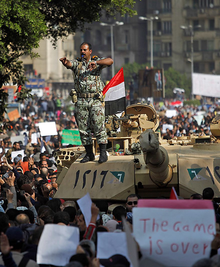 An Egyptian army lieutenant colonel stands on top of a tank as demonstrators arrive in Tahrir, or Liberation, Square in Cairo on Tuesday, Feb. 1, 2011. More than a quarter-million people flooded into the heart of Cairo, filling the city's main square in by far the largest demonstration in a week of unceasing demands for President Hosni Mubarak to leave after nearly 30 years in power. (AP Photo/Emilio Morenatti)