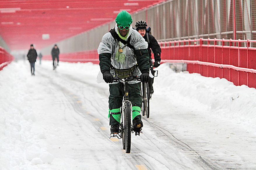 Morning commuters make their way over a snow-covered Williamsburg Bridge on Tuesday, Feb. 1, 2011, in New York. (AP Photo/Mary Altaffer)