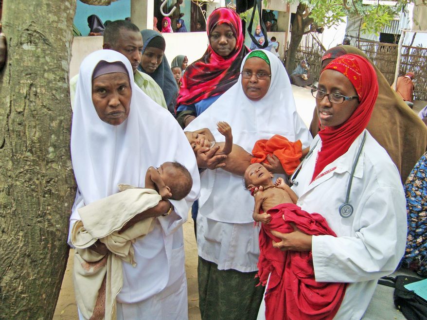 Dr. Amina Adan Mohamed (right) holds one of 37 malnourished infants awaiting treatment at her mother's hospital in Afgoye, Somalia. Dr. Hawa Abdi and her daughters are known throughout Somalia as healers and protectors who don't distinguish among clans, religions or political creeds. (Associated Press)