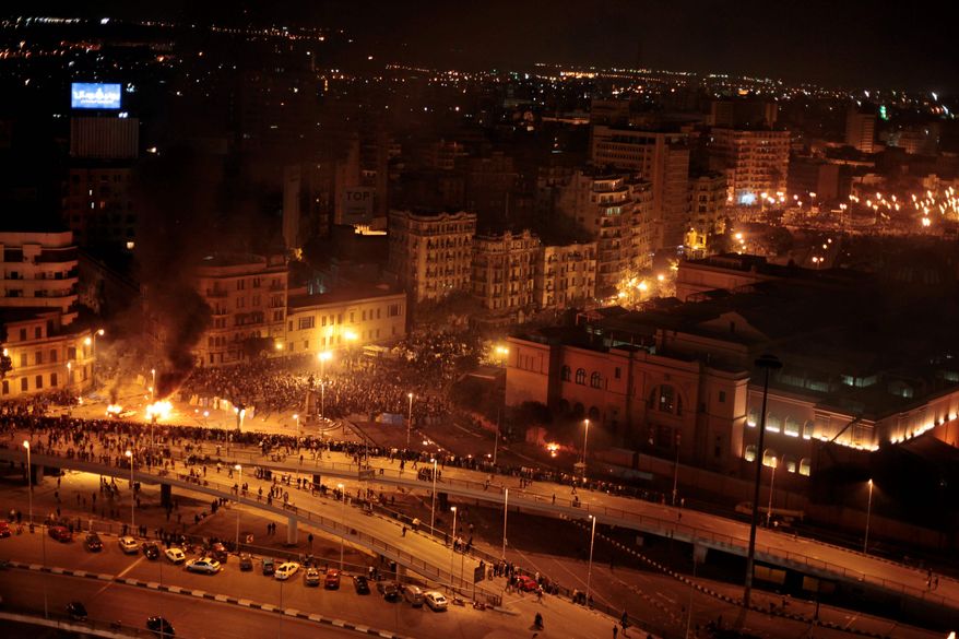 Smoke rises from cars on fire during clashes between pro-government and anti-government demonstrators in Cairo's Tahrir Square early Thursday. (Associated Press)