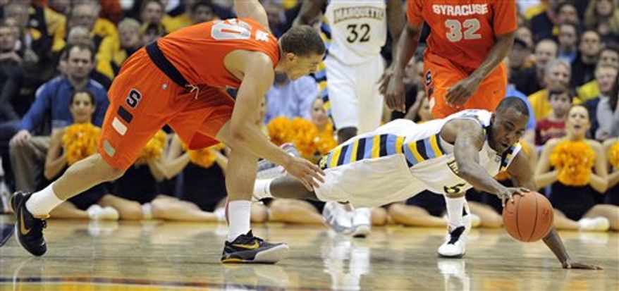 Syracuse's Brandon Triche (20) and Marquette's Junior Cadougan (5) dive for a loose ball during the second half of an NCAA college basketball game Saturday, Jan. 29, 2011, in Milwaukee. (AP Photo/Jim Prisching)