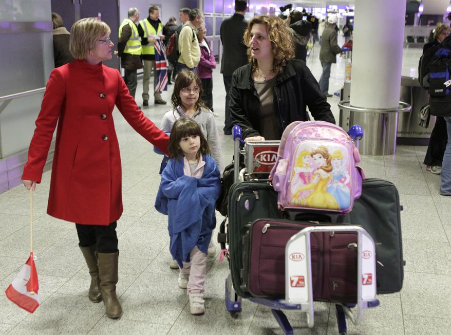 A Canadian mother and her two children are welcomed by an employee of the Canadian Embassy at Frankfurt Airport in Germany on Tuesday, Feb. 1, 2011, after they were flown out of Cairo by Air Canada. (AP Photo/Michael Probst)