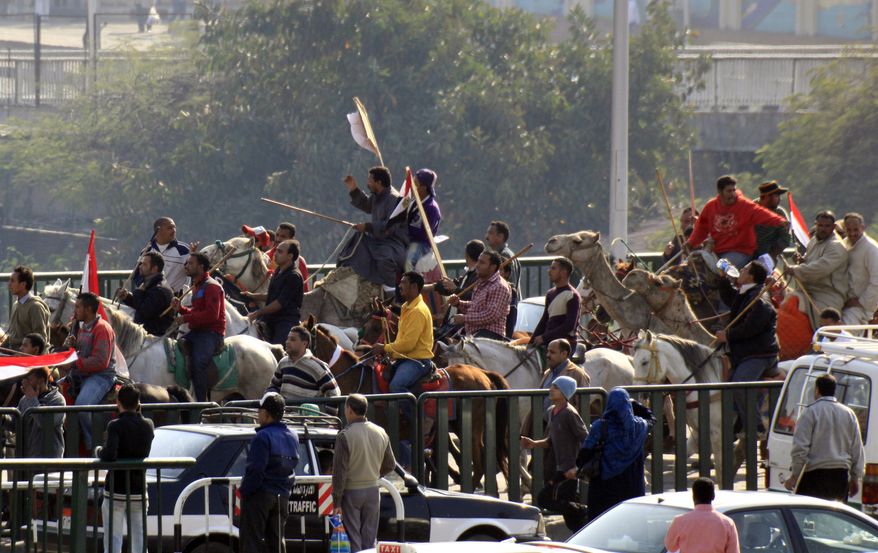 Supporters of Egyptian President Hosni Mubarak, including some riding horses and camels and wielding whips, march toward anti-Mubarak protesters in Cairo on Wednesday, Feb. 2, 2011. (AP Photo/Amr Nabil)