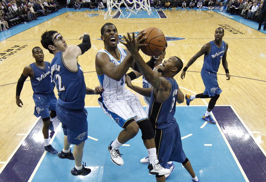New Orleans Hornets point guard Chris Paul, center, shoots over Washington Wizards point guard John Wall, from left, guard Kirk Hinrich, forward Rashard Lewis and forward Andray Blatche in the second half of an NBA basketball game in New Orleans, Tuesday, Feb. 1, 2011. Paul contributed 15 points and 9 assists in New Orleans' 97-89 win over Washington. (AP Photo/Patrick Semansky)