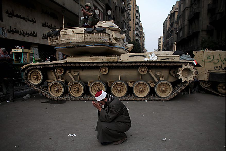An Egyptian Muslim cleric cries in front of on army tank in Tahrir, or Liberation square, in Cairo Wednesday, Feb. 2, 2011. Several thousand supporters of President Hosni Mubarak, including some riding horses and camels and wielding whips, clashed with anti-government protesters Wednesday as Egypt's upheaval took a dangerous new turn. (AP Photo/Tara Todras-Whitehill)
