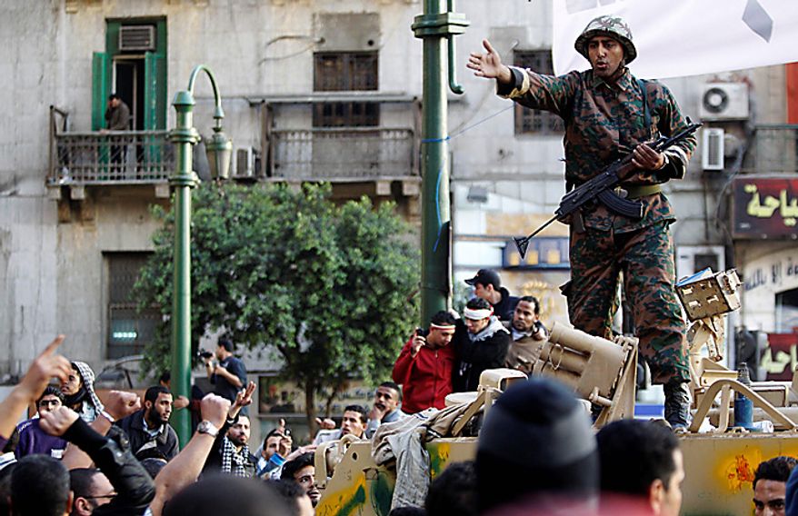 An Egyptian soldier atop an armored personnel carrier tries to clam down anti-government demonstrators, who charged to clash with pro-government protesters in Tahrir Square, in Cairo Wednesday, Feb. 2, 2011. Several thousand supporters of President Hosni Mubarak clashed with anti-government protesters as Egypt's upheaval took a dangerous new turn. (AP Photo/Lefteris Pitarakis)