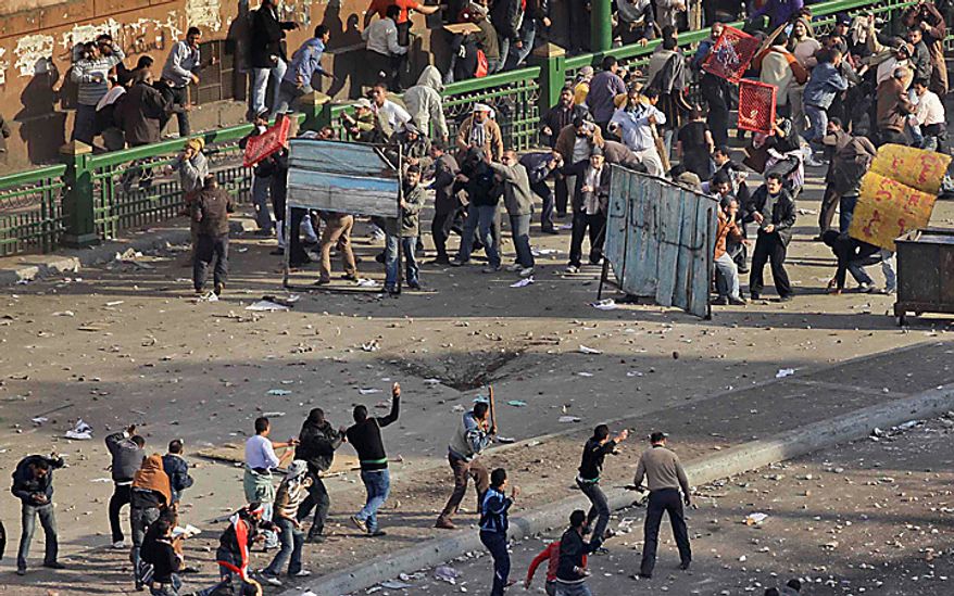 Pro-government demonstrators, below, clash with anti-government demonstrators, above, opposite the Egyptian Museum in Cairo, Egypt, Wednesday, Feb. 2, 2011. (AP Photo/Ben Curtis)