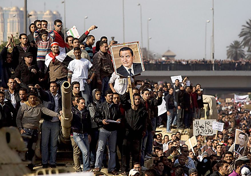 Pro-government demonstrators show their support for Egyptian President Hosni Mubarak during a demonstration in Cairo on Wednesday, Feb. 2, 2011. Several thousand Mubarak supporters, including some riding horses and camels and wielding whips, clashed with anti-government protesters as Egypt's upheaval took a dangerous new turn. In chaotic scenes, the two sides pelted each other with stones, and protesters dragged riders off their horses. (AP Photo/Sebastian Scheiner)